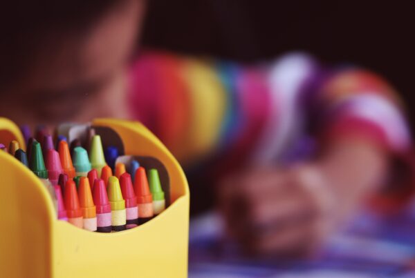 Child colouring with crayons